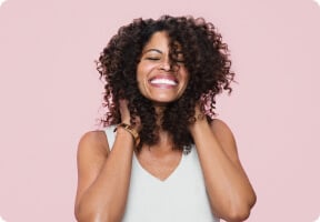 Mujer tocnado su cabello rizado castaño intenso