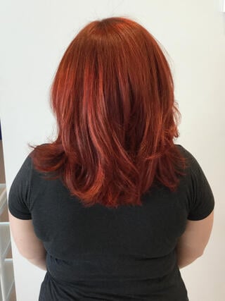 Foto "después": vista trasera de una mujer con cabello castaño uniforme de longitud media, después de la coloración.