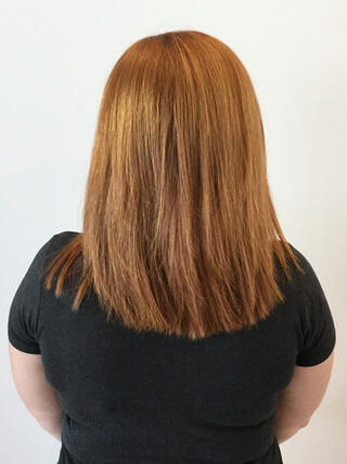 Before Photo: rear view of woman with medium length uneven light brown hair with grown out roots before color.