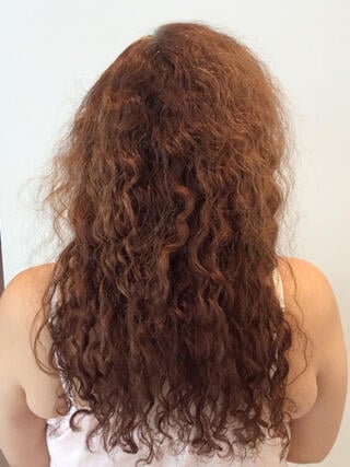 Before Photo: rear view of woman with long damaged red hair before color.